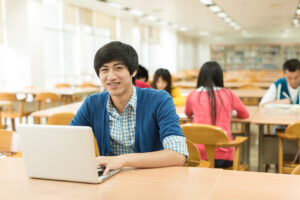 Asian college students studying with laptop in library